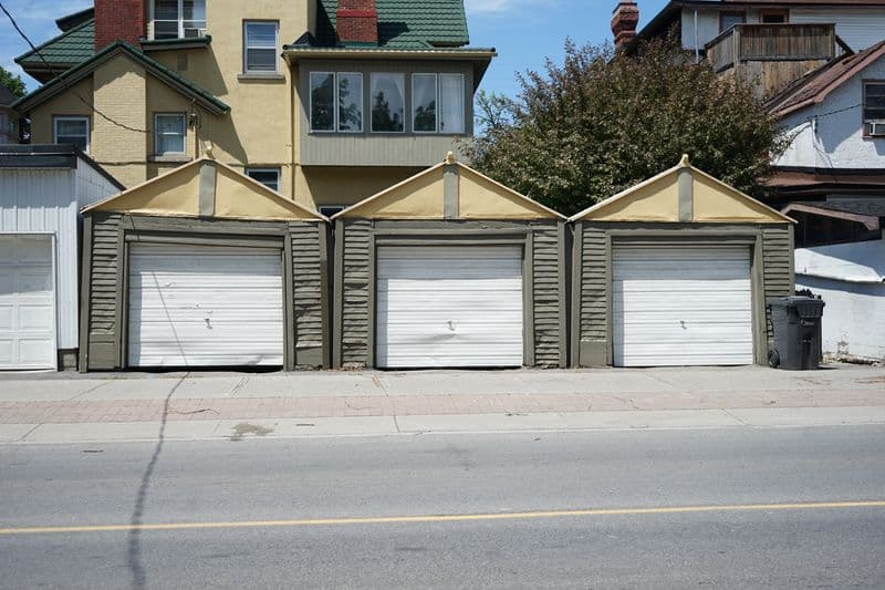 Row of white residential garage doors on a sunny day
